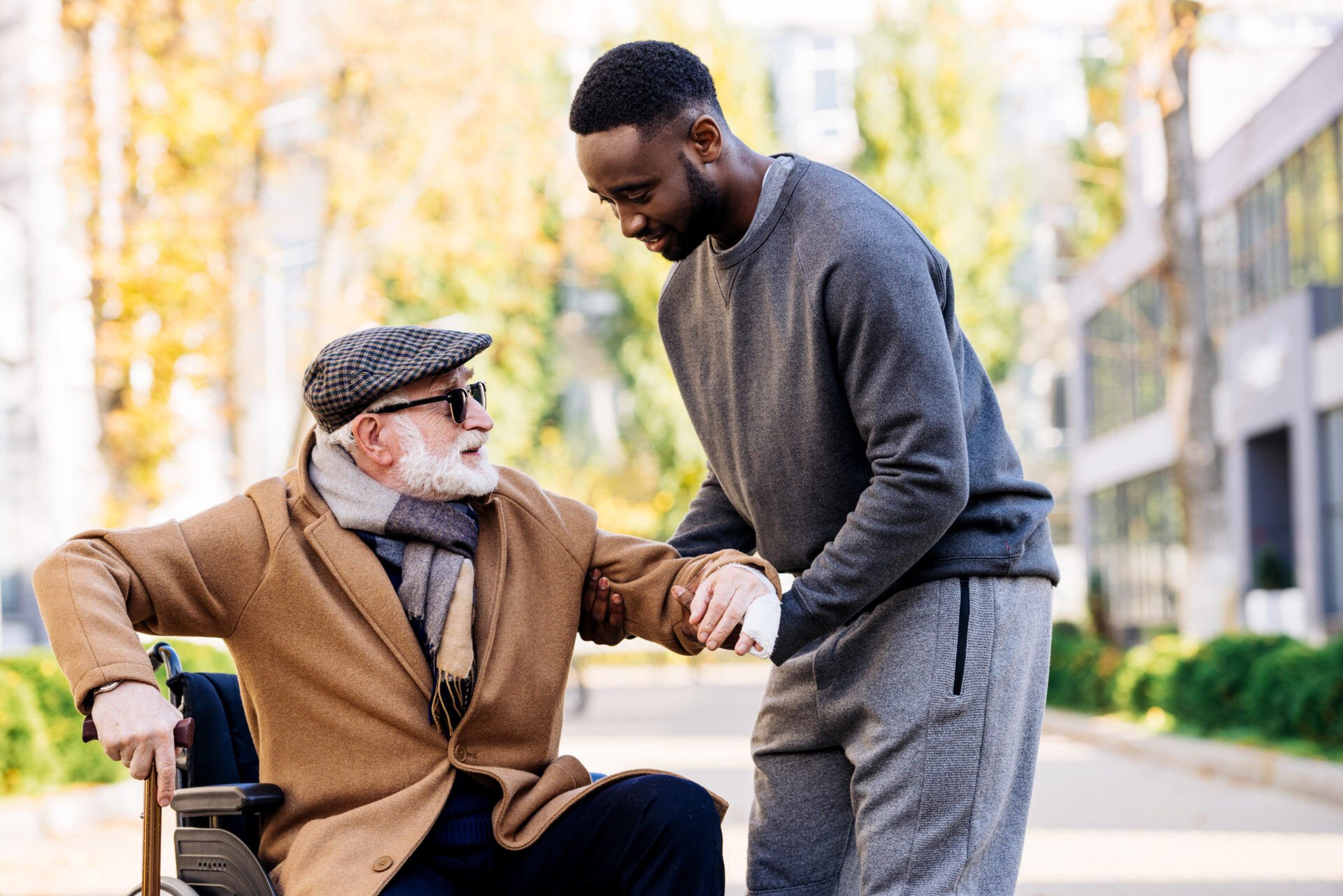 Caregiver-helping-elderly-man-out-of-wheelchair